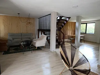 a living room with a couch and a spiral staircase at Alma Guatapé in Guatapé
