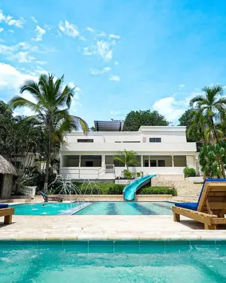 a swimming pool with a slide in front of a house at Sky Natural Museum in Santa Fe de Antioquia