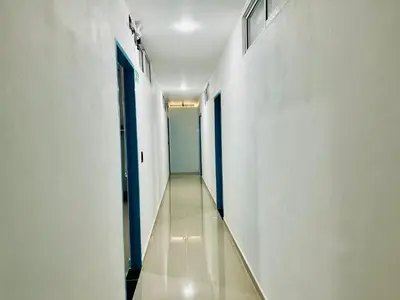 a hallway with white walls and a blue door at Amanecer Santorini in Estación El Salto