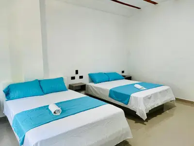 two beds in a room with blue and white at Amanecer Santorini in Estación El Salto