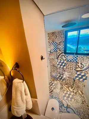 a bathroom with a toilet and a mosaic tile wall at GUATAPE By MONTE GANDOLFO in Chiquinquirá