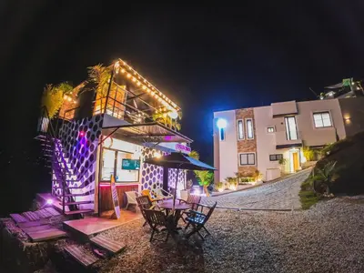a building with a table and chairs at night at GUATAPE By MONTE GANDOLFO in Chiquinquirá