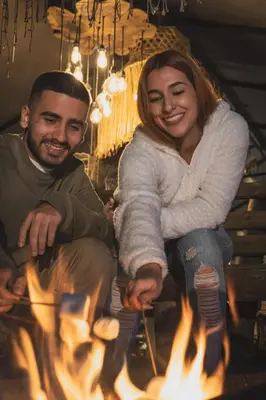 a man and a woman sitting around a fire at GUATAPE By MONTE GANDOLFO in Chiquinquirá