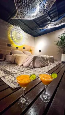 two martini glasses on a wooden table in a bedroom at MORITZ By MONTE GANDOLFO in Chiquinquirá