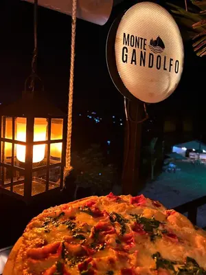 a pizza sitting on a table with a lamp and a baseball at MORITZ By MONTE GANDOLFO in Chiquinquirá