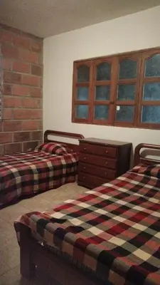a bedroom with two beds and a dresser and window at Escapada Rural, Finca Espaciosa y Relajante en el Corazón de la Naturaleza in Sopetran