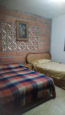 a bedroom with two beds and a brick wall at Escapada Rural, Finca Espaciosa y Relajante en el Corazón de la Naturaleza in Sopetran