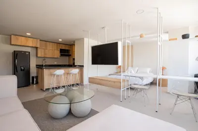 a kitchen and living room with a table and chairs at Elegant apt in Laureles The best area in Medellin in Medellín