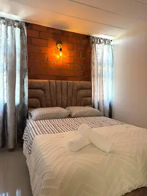 a bedroom with a bed with a brick wall at Casa Macrame El Carmen de Viboral in Carmen de Viboral