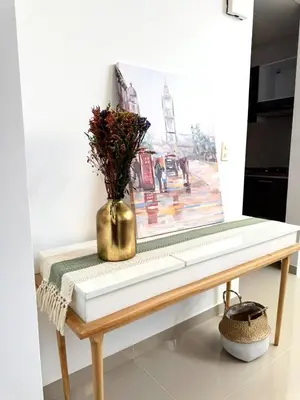 a vase of flowers on a table with a painting at Casa Macrame El Carmen de Viboral in Carmen de Viboral