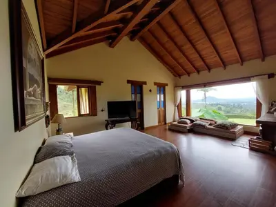 a bedroom with a large bed and a large window at Casa de Campo, La Suiza in La Ceja, Antioquia in La Ceja