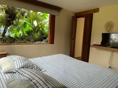 a bedroom with a bed and a large window at Casa de Campo, La Suiza in La Ceja, Antioquia in La Ceja