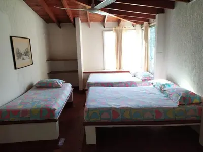 two beds in a room with a window at Finca Las Dos Palmas, San Jeronimo in San Jerónimo