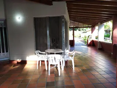 a table and chairs on the porch of a house at Finca Las Dos Palmas, San Jeronimo in San Jerónimo