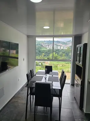 a dining room with a table and chairs and a large window at Vancouver 102 in Villamaría