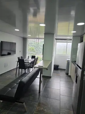 a dining room with a table and chairs and a kitchen at Vancouver 102 in Villamaría