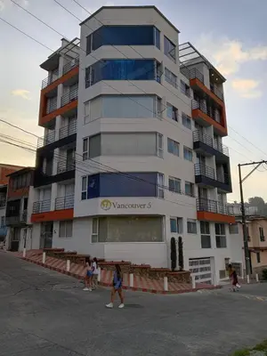 a tall building with people walking in front of it at Vancouver 201 in Villamaría