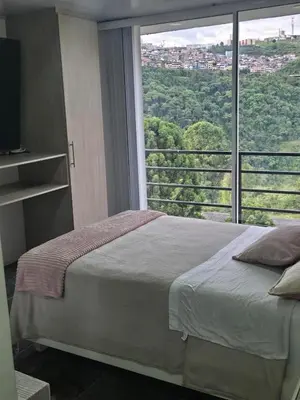 a bedroom with a bed and a large window at Vancouver 402 in Villamaría