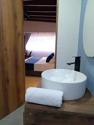 a bathroom with a white sink and a bedroom at Bluelux Med - B&B in Medellín