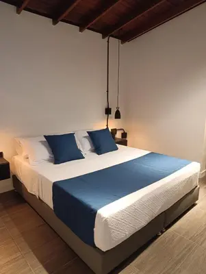 a bedroom with a large bed with blue pillows at Bluelux Med - B&B in Medellín