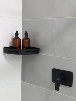 two bottles on a shelf on a bathroom wall at Bluelux Med - B&B in Medellín