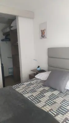 a bedroom with a bed with a white wall at Central apartamento en la Estrella in La Estrella