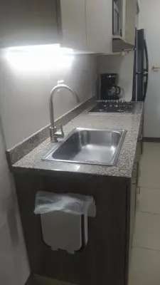 a kitchen counter with a sink and a stove at Central apartamento en la Estrella in La Estrella