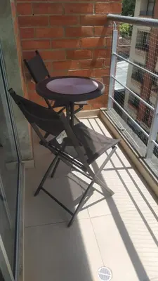 a table and a chair sitting on a balcony at Central apartamento en la Estrella in La Estrella