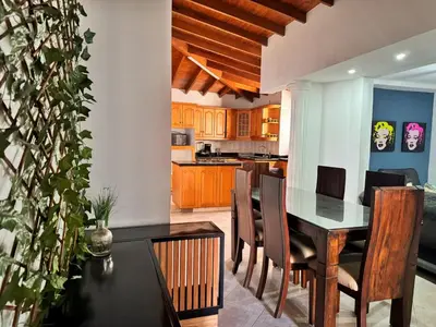 a kitchen and dining room with a table and chairs at Apartamentos compostela in Medellín