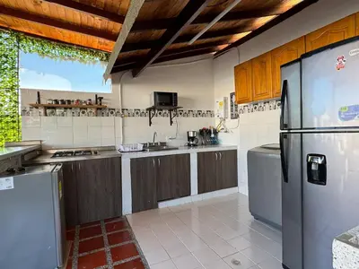 a kitchen with stainless steel appliances and wooden cabinets at Apartamentos compostela in Medellín