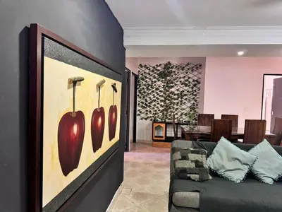 a living room with a couch with a painting of apples at Apartamentos compostela in Medellín