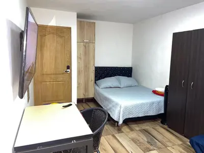 a small room with a bed and a desk at Coliving Belen Malibu in Medellín