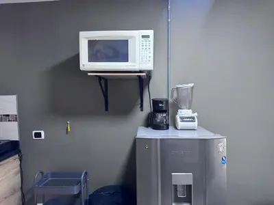 a microwave sitting on a shelf next to a refrigerator at Coliving Belen Malibu in Medellín