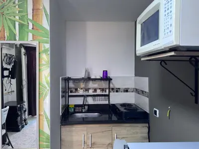 a kitchen with a sink and a microwave at Coliving Belen Malibu in Medellín