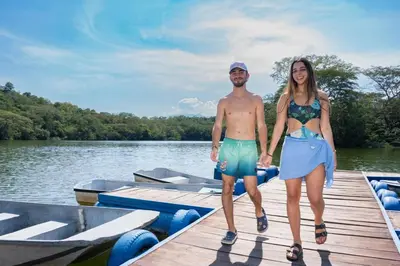 a man and a woman standing on a dock on a boat at Hostería Florida Tropical in Santa Fe de Antioquia