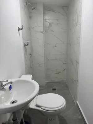 a white bathroom with a toilet and a sink at Villa Loreto Aparta estudio 202 in Medellín