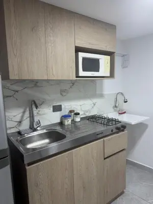 a kitchen with a sink and a microwave at Villa Loreto Aparta estudio 202 in Medellín