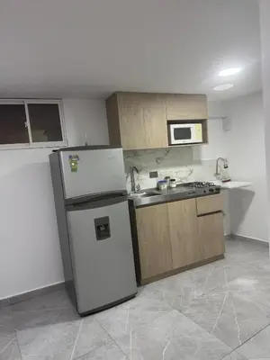 a kitchen with a refrigerator and a sink at Villa Loreto Aparta estudio 202 in Medellín