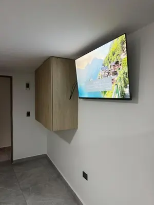 a flat screen tv hanging on a wall at Villa Loreto Aparta estudio 202 in Medellín