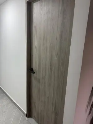 a wooden door in a room with a white wall at Villa Loreto Aparta estudio 202 in Medellín