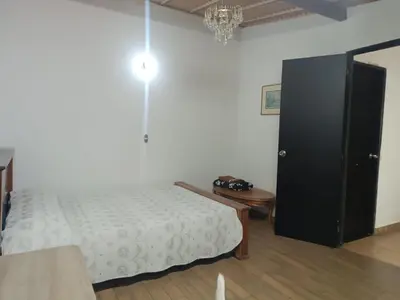 a bedroom with a bed and a table and a black cabinet at Alcoba amplia con cama doble in Envigado