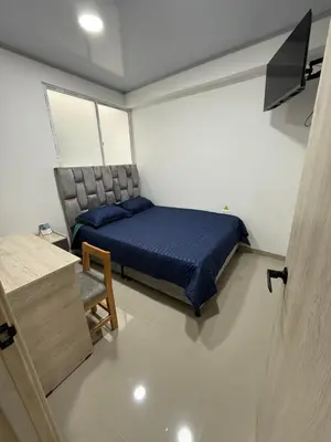 a small bedroom with a bed and a chair at Hotel El Samán in Quinchía