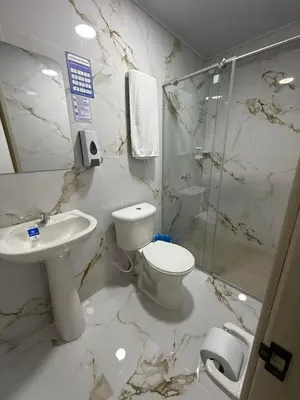 a bathroom with a toilet and a sink and a shower at Hotel El Samán in Quinchía