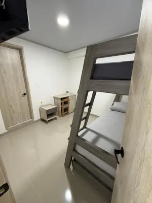 a room with a bunk bed and a television at Hotel El Samán in Quinchía