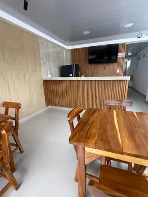 a dining room with a wooden table and chairs at Hotel El Samán in Quinchía