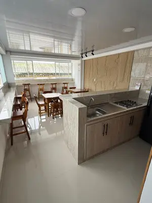 a kitchen with a counter and a table and chairs at Hotel El Samán in Quinchía