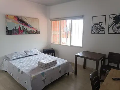 a bedroom with a bed and a table and a window at Apartaestudios Santa Ana in Ruiosucio
