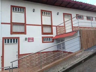 a white building with red and white doors and stairs at Apartaestudios Santa Ana in Ruiosucio