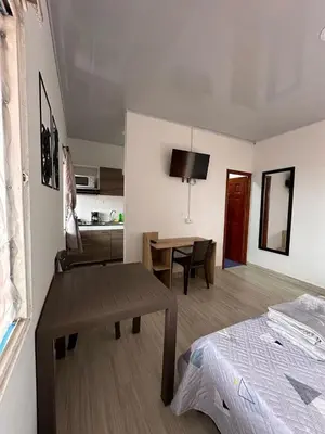 a room with a bed and a table and a kitchen at Apartaestudios Santa Ana in Ruiosucio