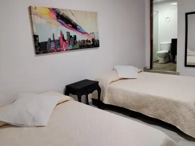two beds in a room with a picture on the wall at Apartaestudios Santa Ana in Ruiosucio